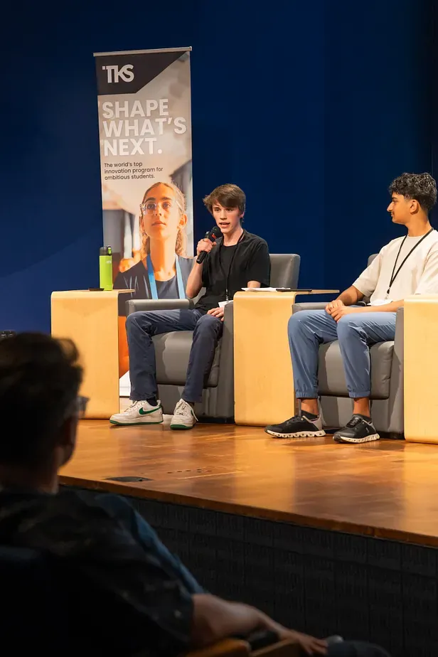 Gabriel speaks into a microphone beside another panellist at the TKS Vancouver Emerging Technology Showcase.