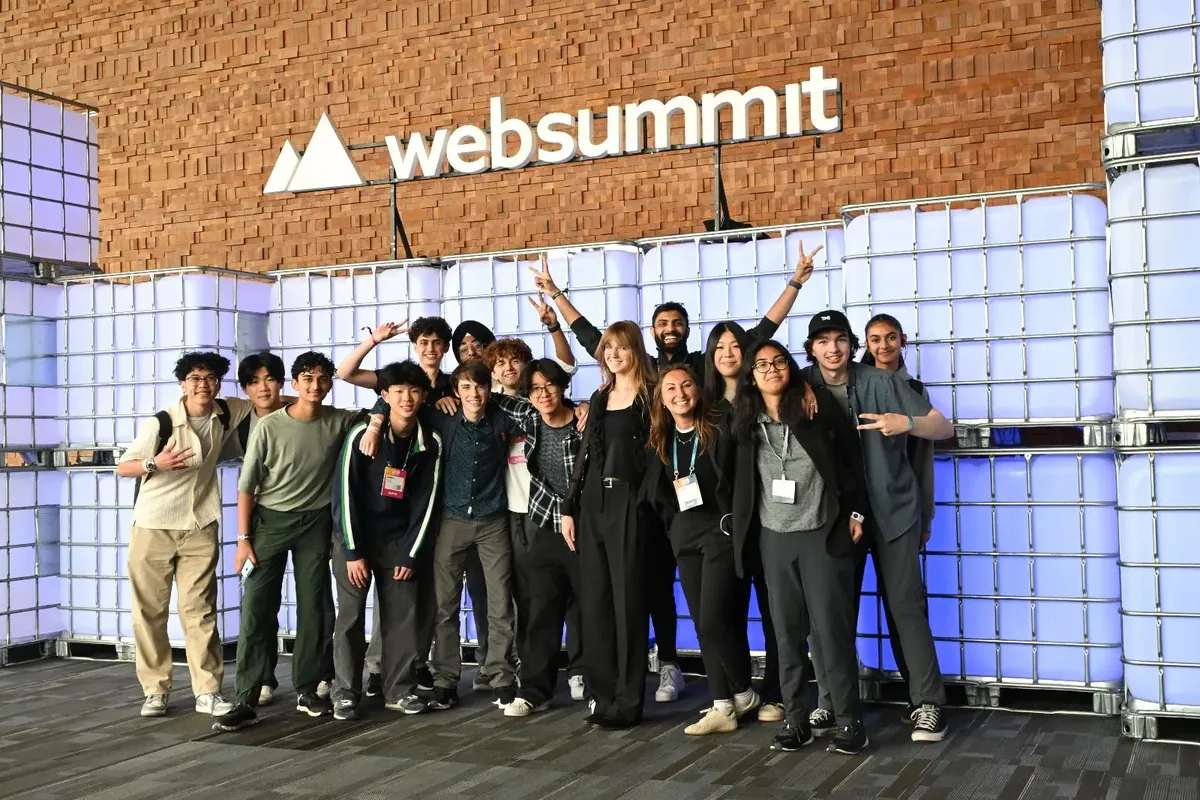 TKS attendees gather beneath the Web Summit sign for a group portrait.