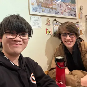 Gabriel and Christopher Lee sit together at a table during their coffee chat.