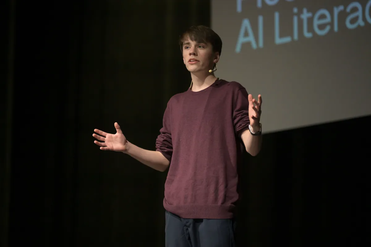Gabriel gestures on stage during his TEDx talk about digital sustainability and AI literacy.
