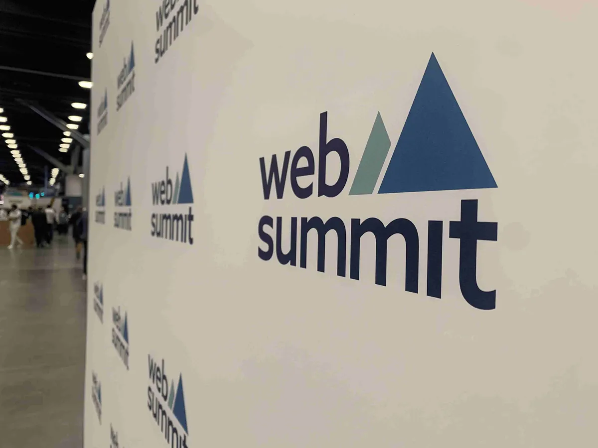 A wall of Web Summit logos welcomes attendees to the conference.
