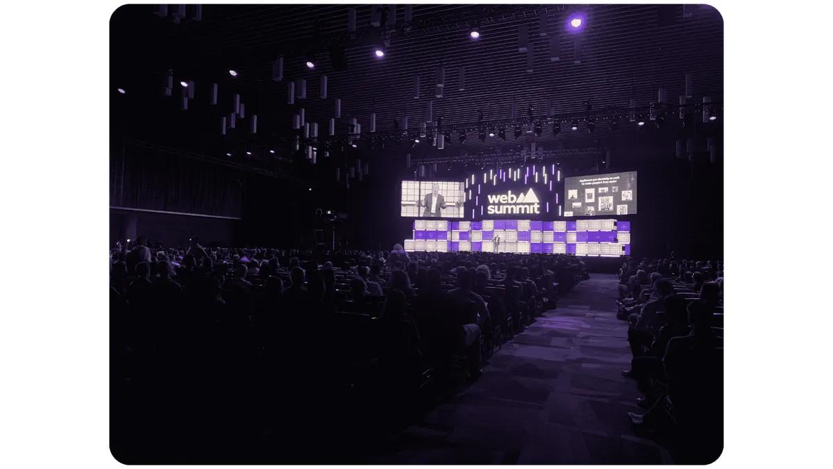 Audience members face the illuminated Web Summit Centre Stage during Brad Smith’s presentation.